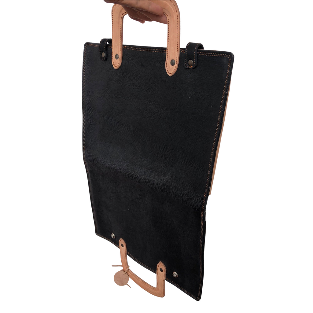 hand holding an open black and tan laptop sleeve